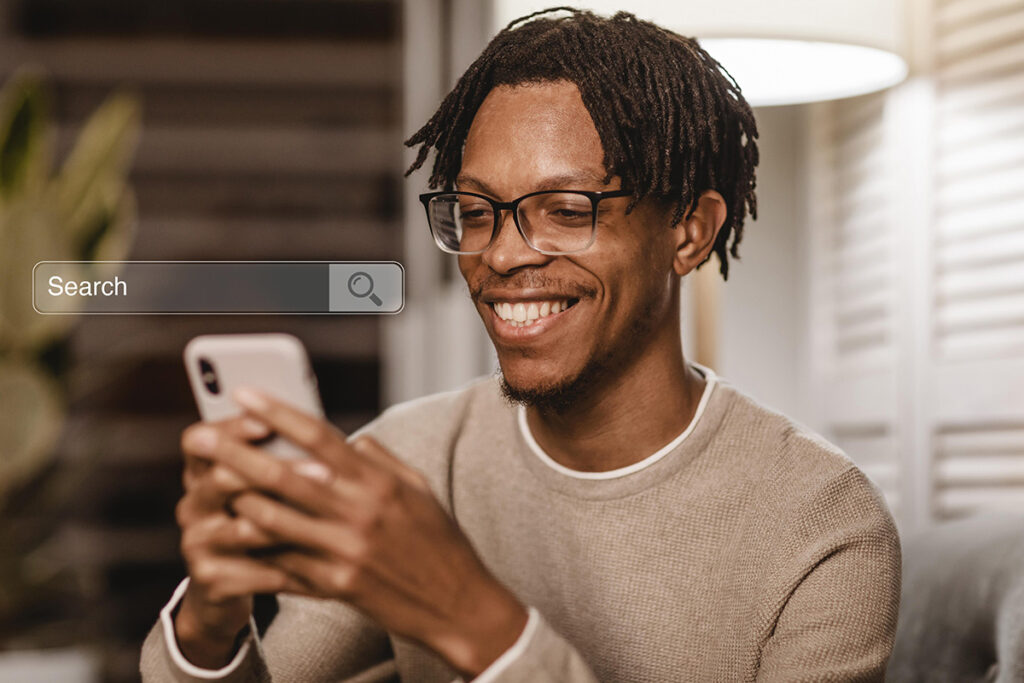 Joven hombre sonríe al comprobar que los consejos para aparecer en Google Discover están teniendo efecto y su contenido se muestra a usuarios.
