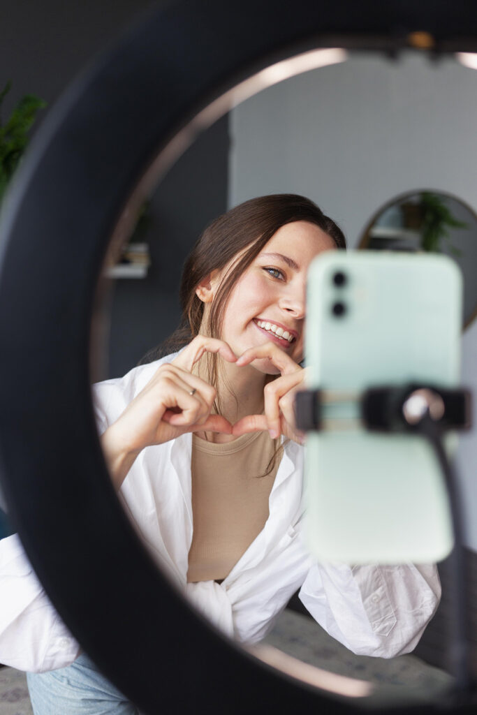 Chica grabando contenido UGC usando un trípode y un aro de luz.
