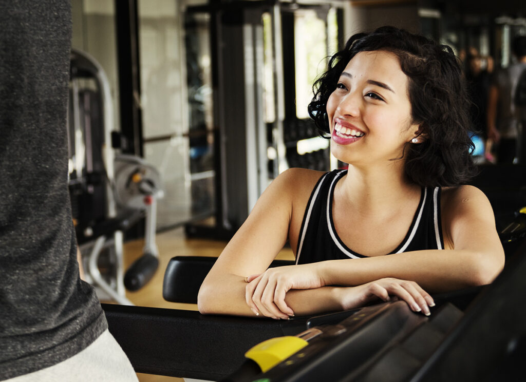 Monitora de gimnasio feliz por atender a sus nuevos socios.
