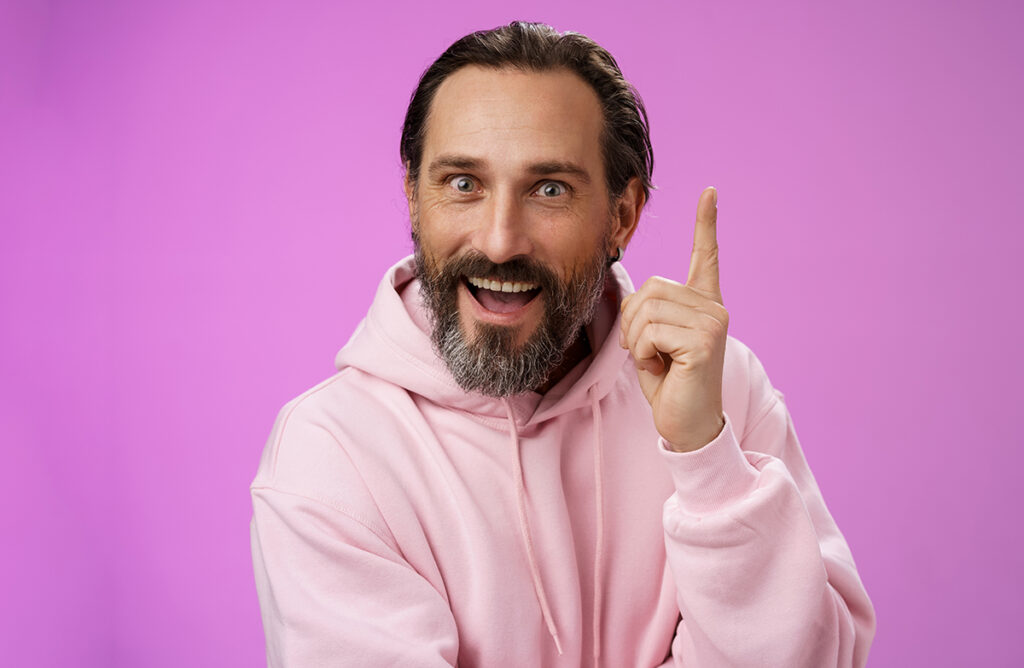 Hombre feliz tras dar con la tecla para redactar un 'quiénes somos' mucho más apropiado para la web de su empresa.